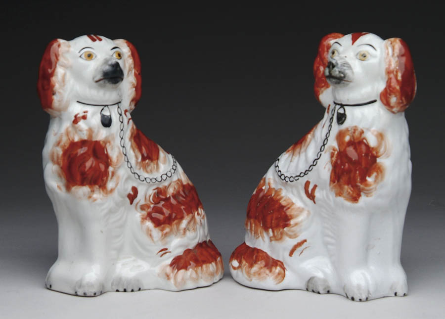 Appraisal: PAIR OF ANTIQUE ENGLISH STAFFORDSHIRE SEATED SPANIELS Terracotta and black