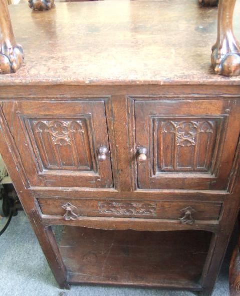 Appraisal: An oak cupboard the pair of carved panel doors over