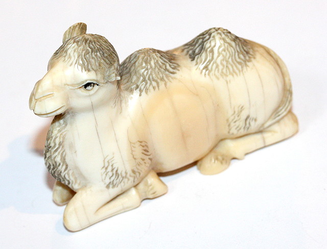 Appraisal: A MARINE IVORY CARVING of a seated camel with carved