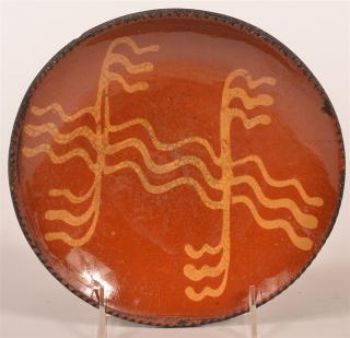 Appraisal: th C PA Redware Pottery Slip Decorated Plate with Coggle