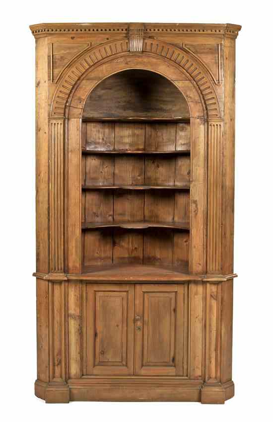 Appraisal: A Continental Carved Pine Corner Cabinet having a dentiled frieze