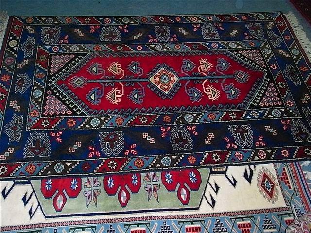 Appraisal: A TURKISH RED GROUND RUG with central panel surrounded by