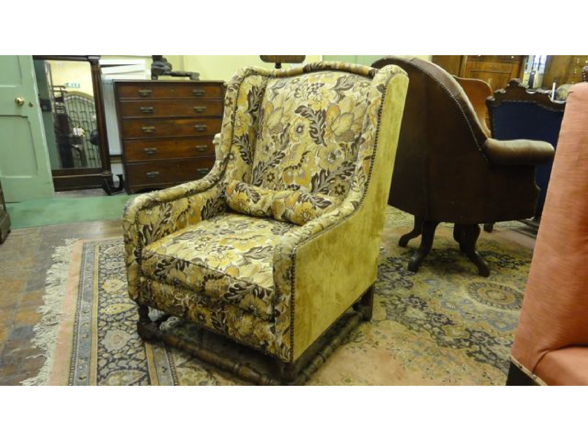 Appraisal: A substantial th century winged armchair on turned supports and