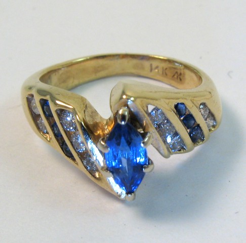 Appraisal: SAPPHIRE AND FOURTEEN KARAT GOLD RING centering a marquise-cut sapphire