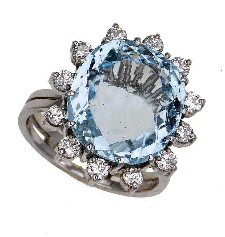 Appraisal: AN AQUAMARINE AND DIAMOND CLUSTER RING the cushion shaped aquamarine