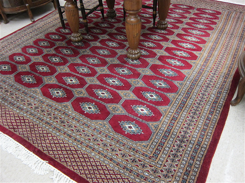 Appraisal: HAND KNOTTED ORIENTAL CARPET Indo-Bokhara red field ' x '