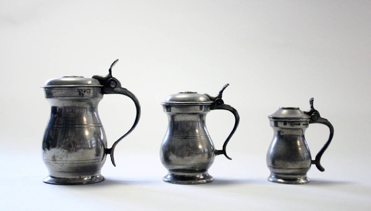 Appraisal: THREE PEWTER LIDDED MEASURES ENGLAND The half gill one gill