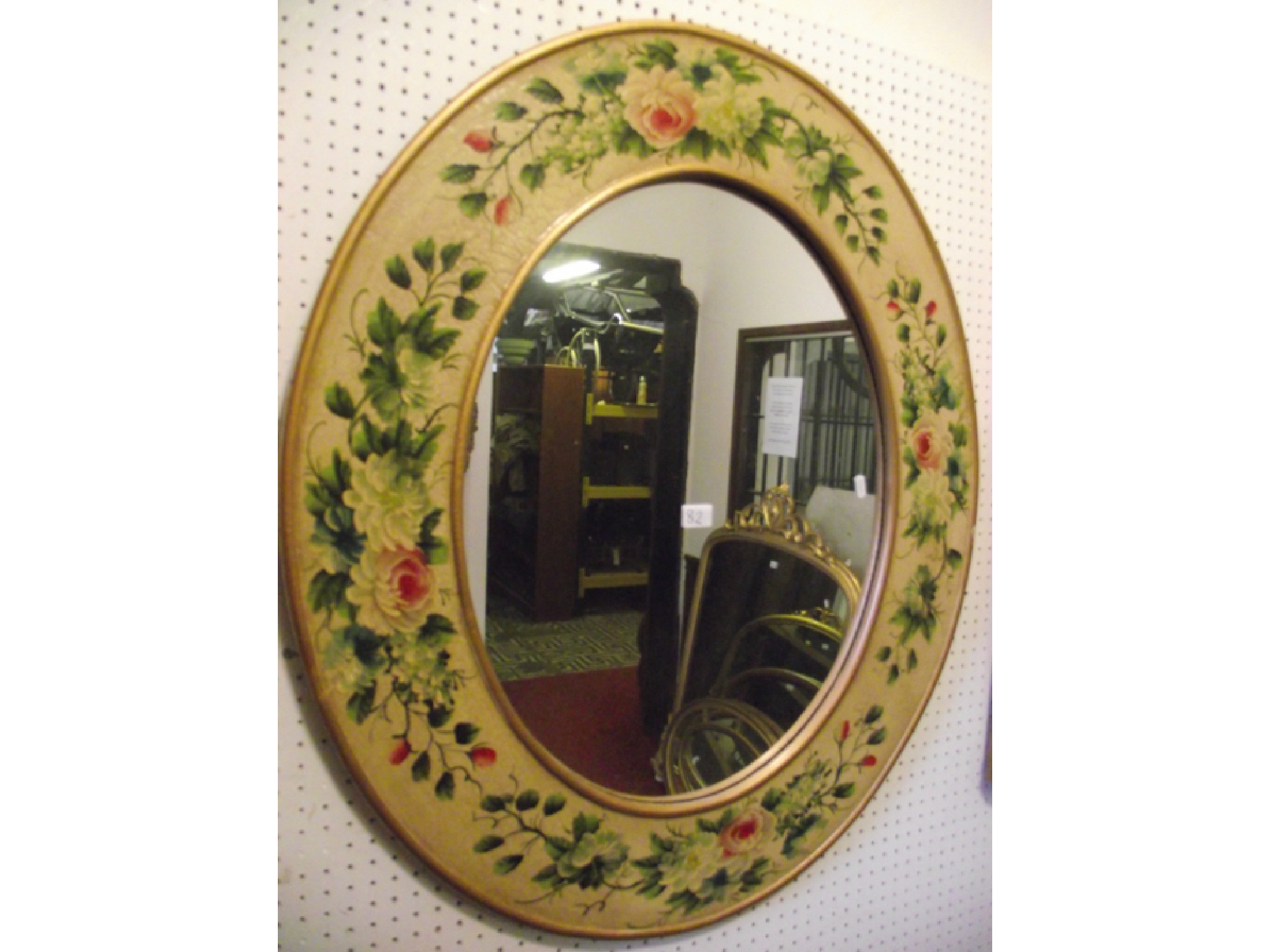 Appraisal: A contemporary wall mirror of oval form with broad trailing