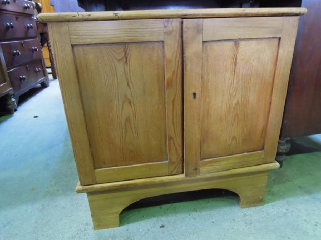 Appraisal: A low stripped and waxed pine side cupboard enclosed by