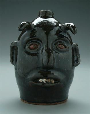 Appraisal: Reggie Meaders devil jug dark olive alkaline glaze ceramic teeth