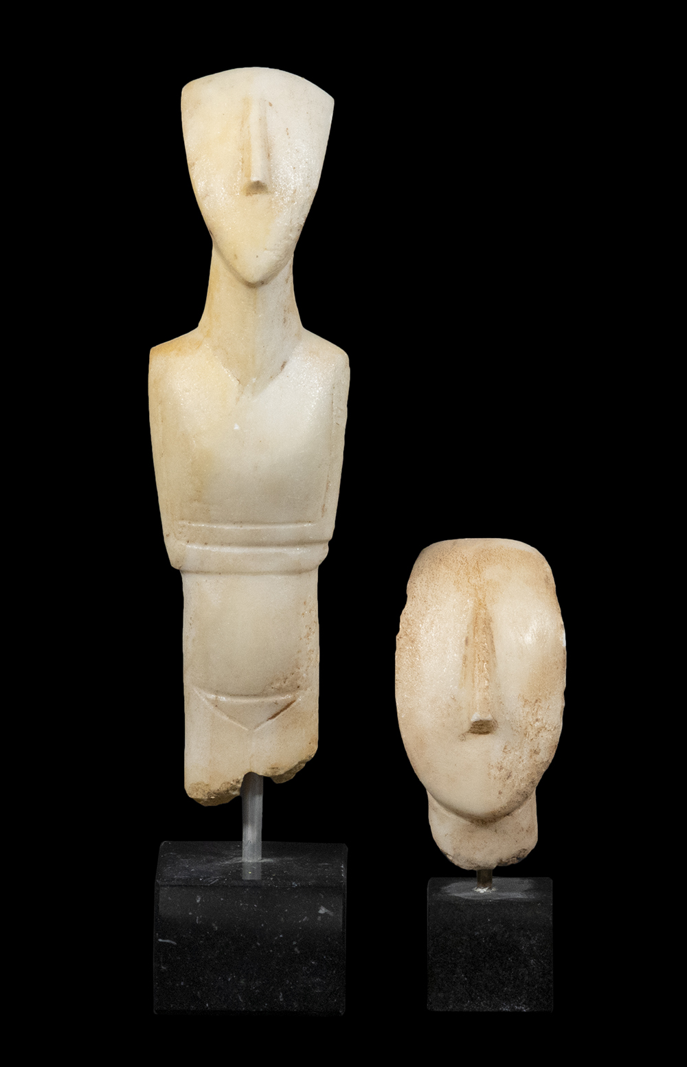 Appraisal: CYCLADIC STYLE MARBLE CARVINGS Standing Male Figure Head carved from