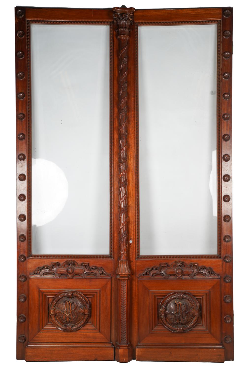 Appraisal: PAIR OF CARVED MAHOGANY BEVELED GLASS DOORSwith monogrammed crest AB