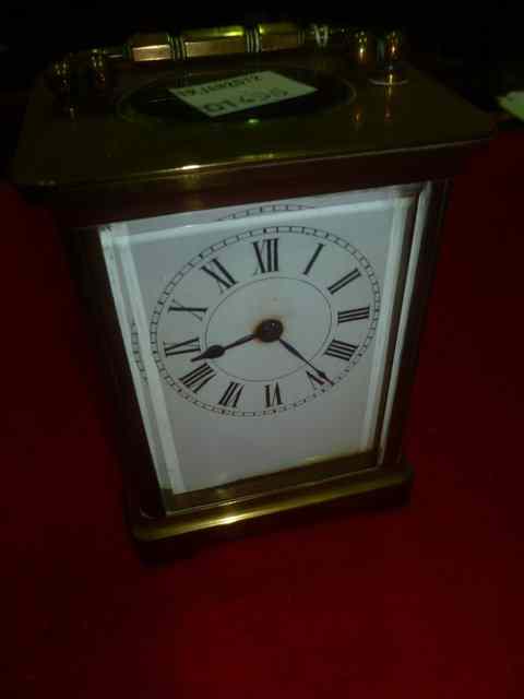 Appraisal: A BRASS CARRIAGE CLOCK with enamel dial and swing handle