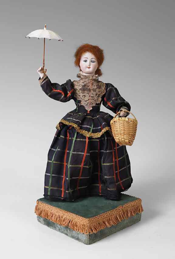 Appraisal: WIND UP MUSICAL AUTOMATON DOLL AND GLASS DOME Bisque head