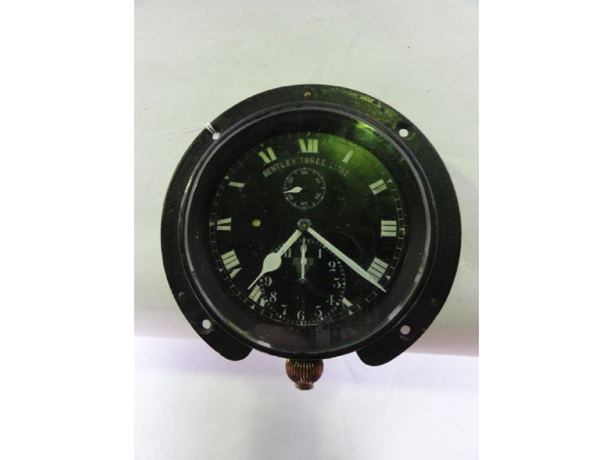 Appraisal: An unusual circular cased car clock with black ground and