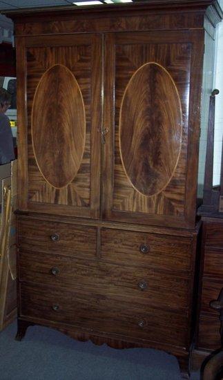 Appraisal: A mahogany linen press the moulded cornice above two oval