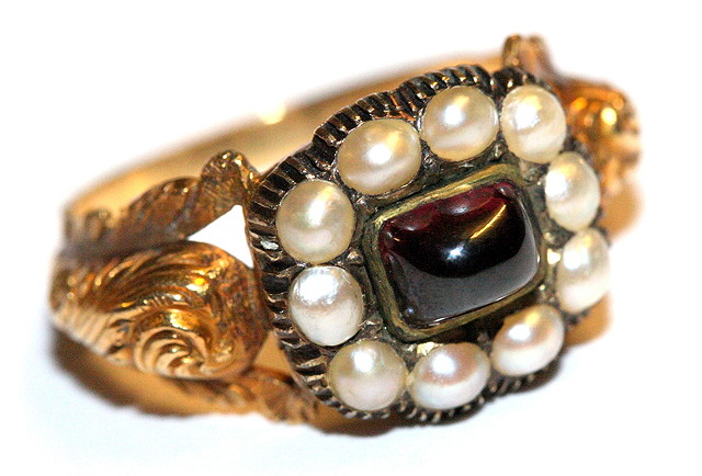 Appraisal: A GARNET AND PEARL SET MOURNING RING oval cabochon cut