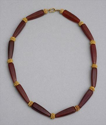 Appraisal: PERSIAN GOLD AND CARNELIAN NECKLACE Faceted longitudinal beads with granulated