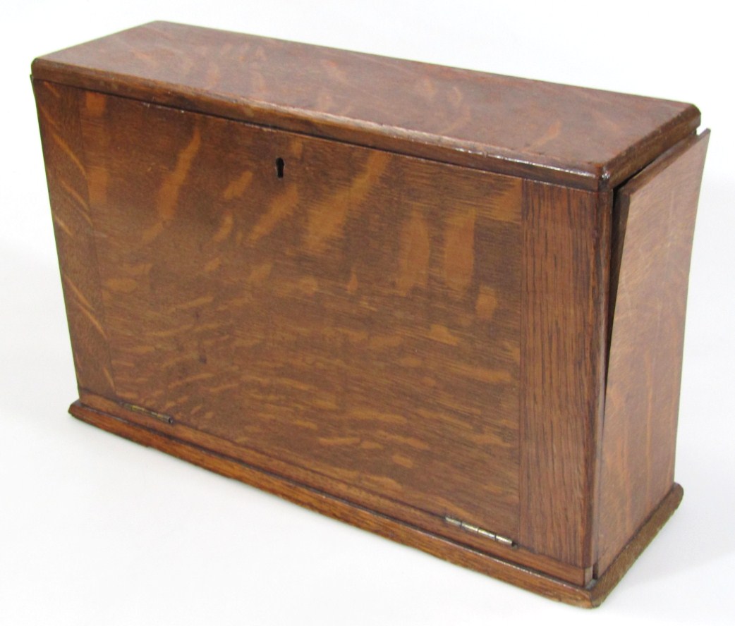 Appraisal: An Edwardian oak stationery cabinet with articulated hinged lid and