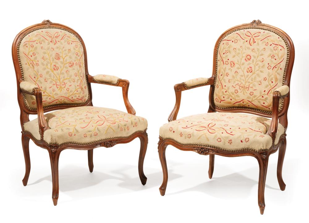 Appraisal: Pair of Louis XV-Style Walnut Fauteuils floral crest padded arms