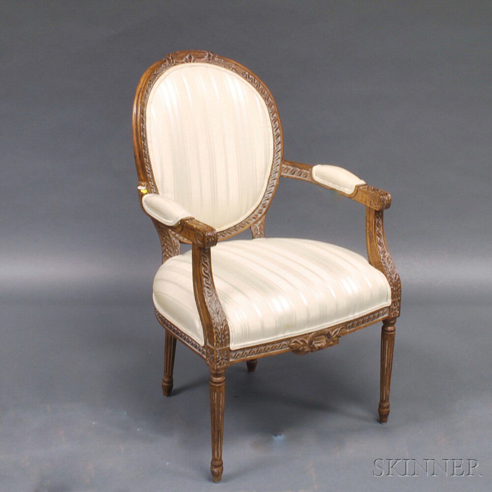 Appraisal: Louis XVI-style Walnut Fauteuil Armchair th century the sprig-carved oval