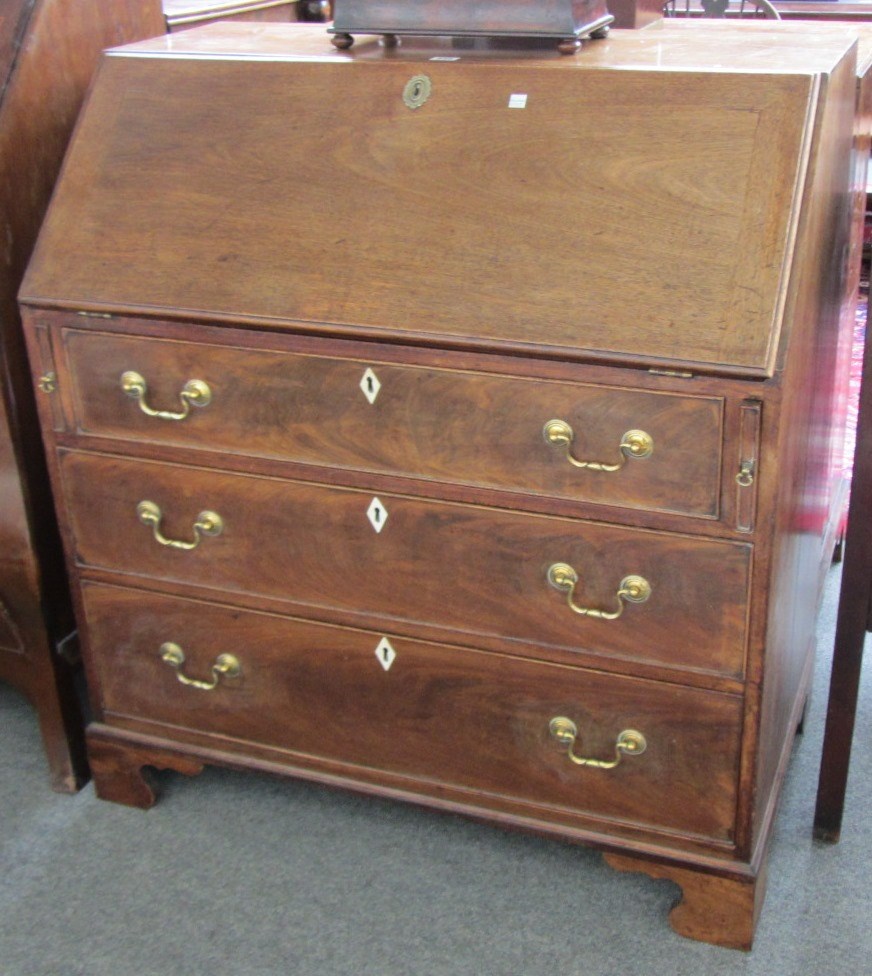 Appraisal: A George III mahogany bureau the fall enclosing a fitted