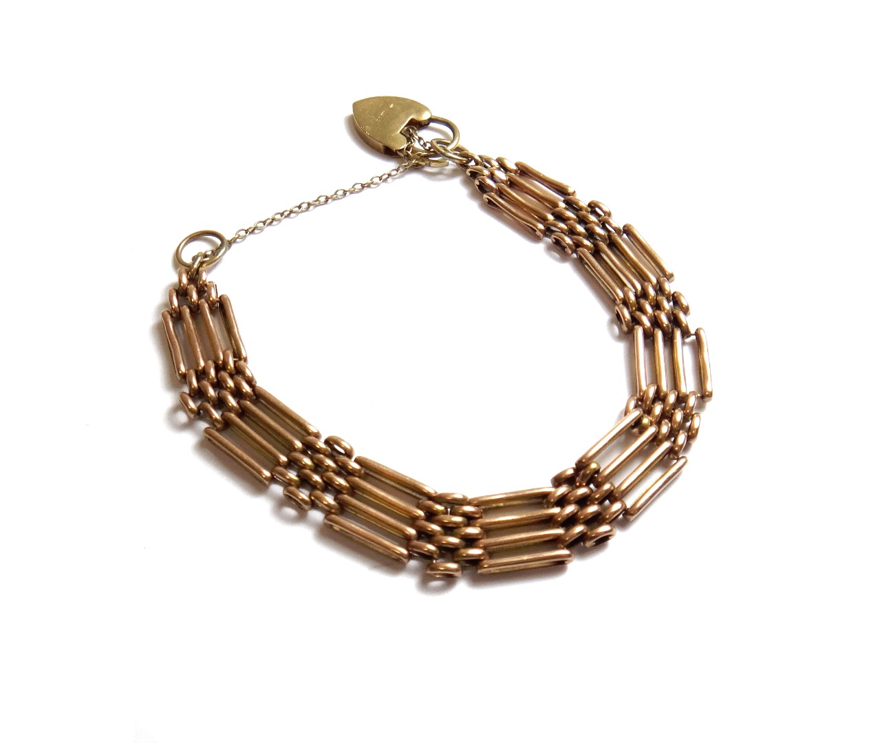 Appraisal: A gold bar and oval link gate bracelet on a