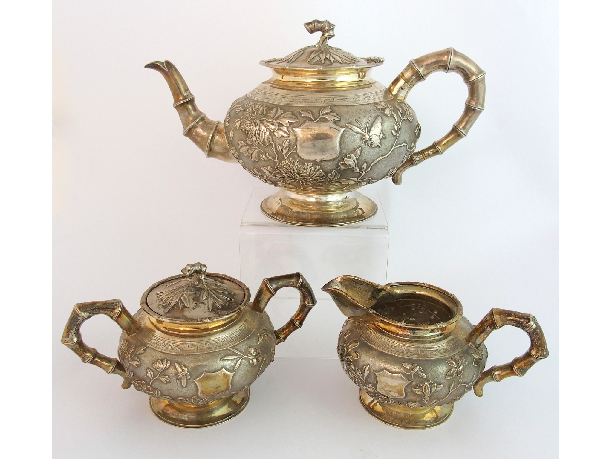 Appraisal: A Chinese silver three piece tea servicedecorated allover with butterflies