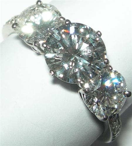 Appraisal: A modern three-stone diamond ring claw set with graduated round