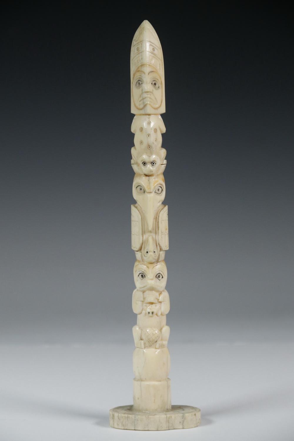 Appraisal: MINIATURE NORTHWEST INDIAN TOTEM Desktop Totem in carved walrus tusk