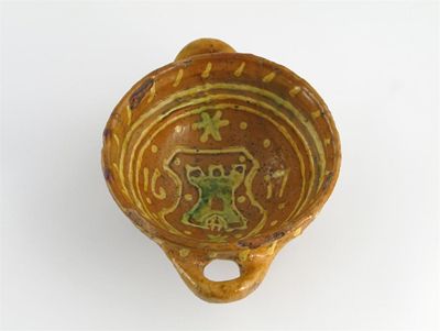 Appraisal: A slipware bowl with two loop handles decorated in a