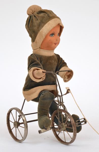 Appraisal: PULL ALONG COMPOSITE HEAD DOLL WITH SOFT BODY RIDING A