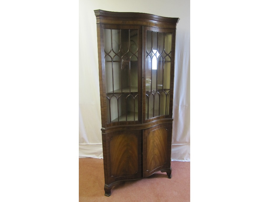 Appraisal: A good reproduction mahogany serpentine shaped corner cabinet the two