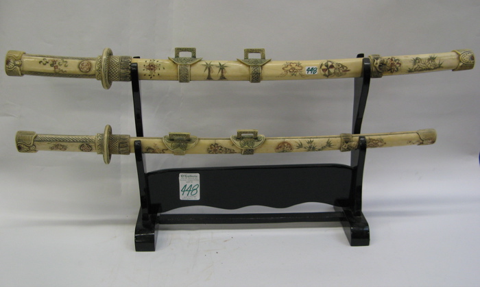 Appraisal: TWO CHINESE POLYCHROME BONE SAMURAI SWORDS displayed on an ebonized