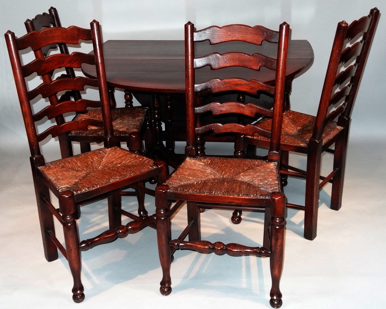 Appraisal: A set of four rush style ladder back chairs on