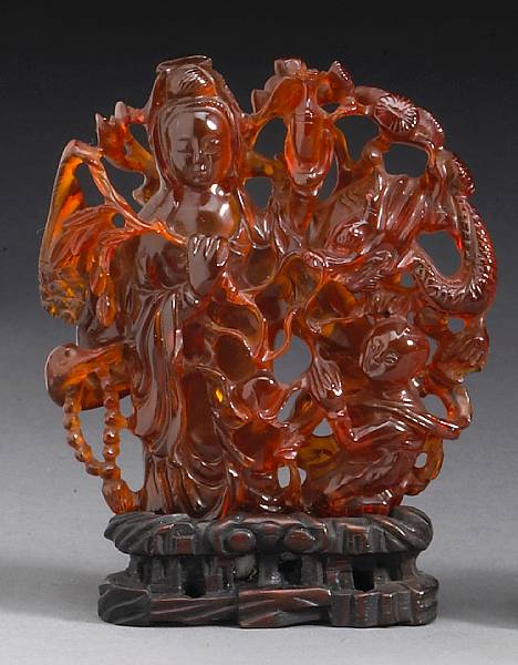 Appraisal: A reticulated amber pebble Late Qing Republican Period Depicting Guanyin