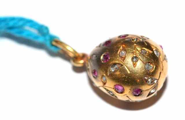 Appraisal: A GOLD CHARM in the form of an egg set