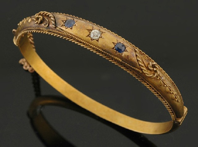 Appraisal: An Edwardian sapphire and diamond bangle The hinged bangle in