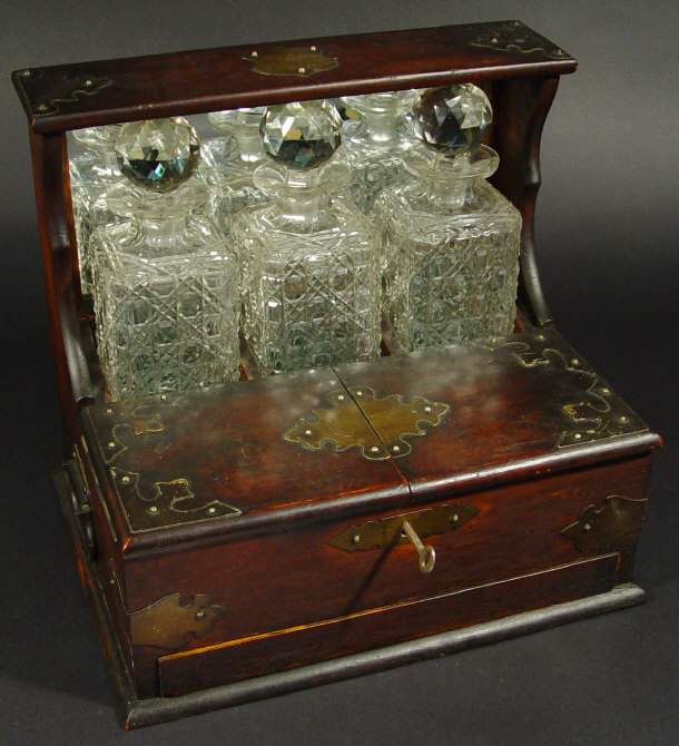 Appraisal: Brass mounted oak three bottle tantalus with lockable hinged flaps