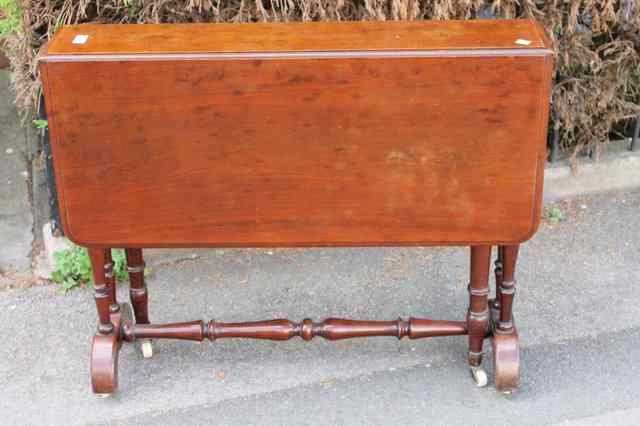 Appraisal: A VICTORIAN MAHOGANY FOLDING TABLE with drop flaps turned stretchers