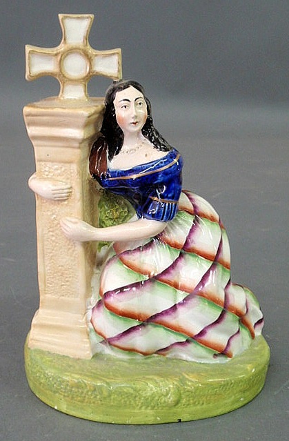 Appraisal: Staffordshire figure of a seated woman embracing a cross depicting