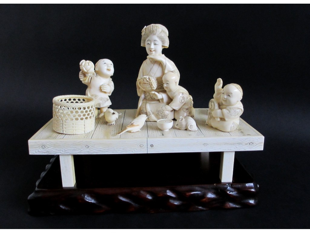 Appraisal: A Japanese carved ivory figure group raised on a plateau