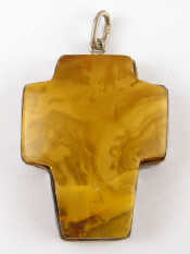 Appraisal: A white metal tests silver mounted amber pendant designed as