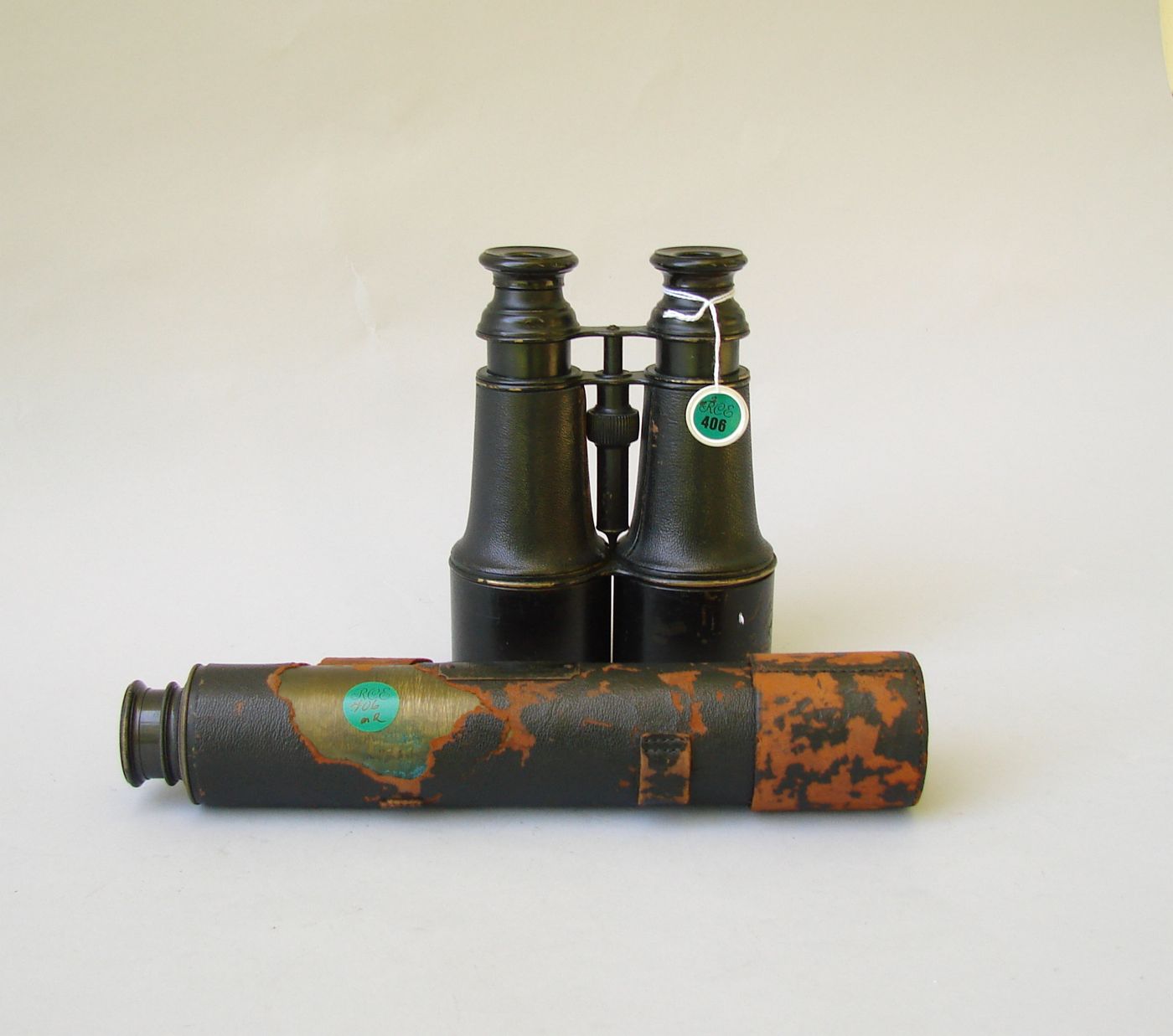 Appraisal: PAIR OF NAVAL BINOCULARS AND A LEATHER-BOUND TELESCOPE A four-draw