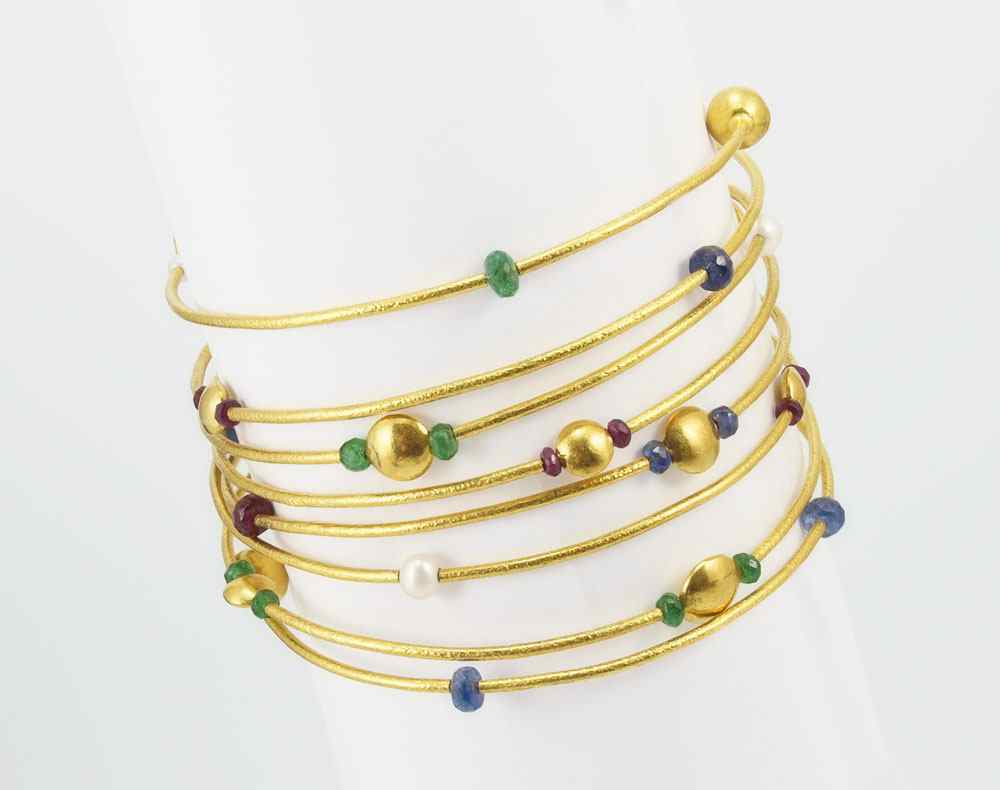 Appraisal: K GEMSTONE WRAP BANGLE BRACELET K yellow gold spiral bangle