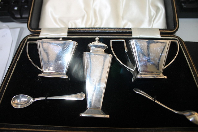 Appraisal: A CASED SILVER CONDIMENT SET of square cut tapering form