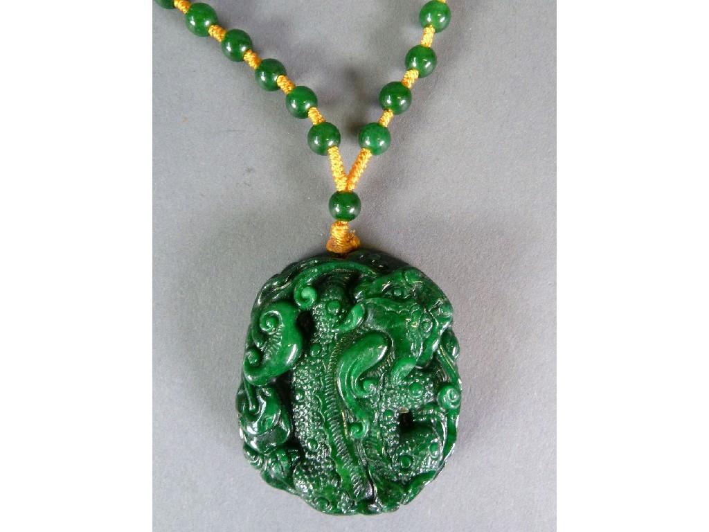 Appraisal: DARK GREEN JADE NECKLACE OF UNIFORM BEADS with a large