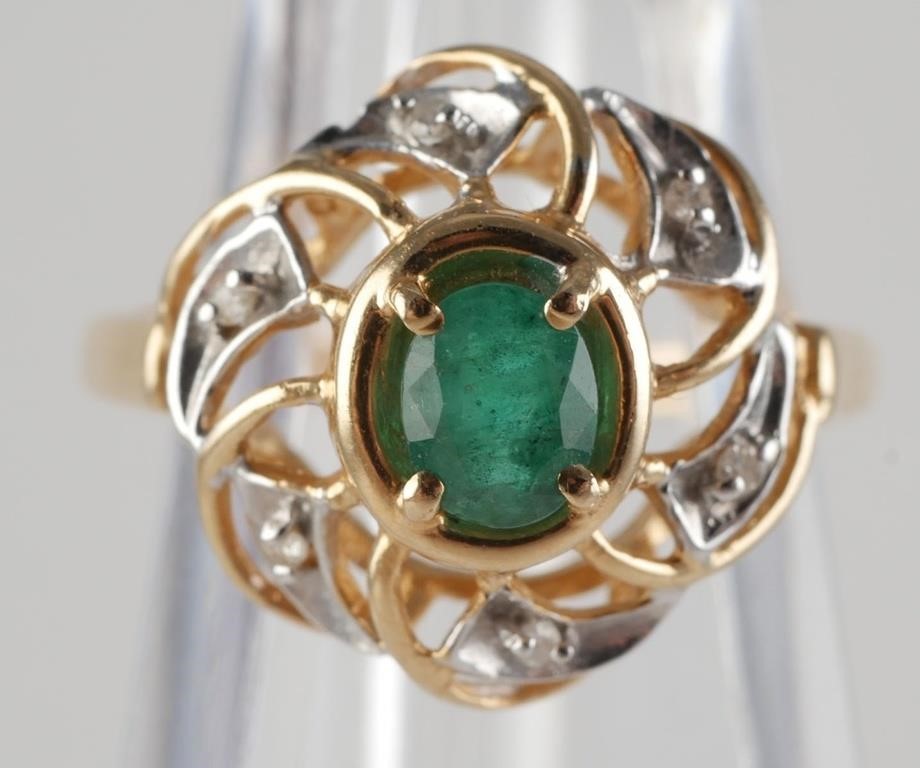 Appraisal: Pretty floral style ring that features a center oval emerald