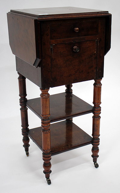 Appraisal: A PLUM PUDDING MAHOGANY VANEERED BEDSIDE TABLE with drop leaves