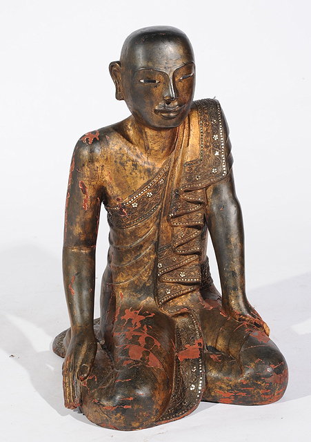 Appraisal: A BURMESE LACQUER KNEELING BUDDHA with traces of gilding and